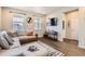 Bright living room featuring a plush sofa, modern decor, and seamless flow to other living spaces at 18809 E 66Th Ave, Denver, CO 80249