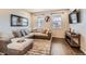 Cozy living room with hardwood floors, a comfortable sectional sofa, and ample natural light at 18809 E 66Th Ave, Denver, CO 80249