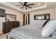 Relaxing main bedroom showcasing a dresser, large mirror, and a comfortable bed with stylish bedding at 18809 E 66Th Ave, Denver, CO 80249
