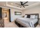 Spacious main bedroom featuring a large bed, ceiling fan, and access to other rooms at 18809 E 66Th Ave, Denver, CO 80249