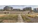 View of landscaped green space and sidewalk adjacent to low-rise residential apartments at 18809 E 66Th Ave, Denver, CO 80249