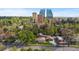 An aerial shot presents the property alongside tall buildings and lush green trees in the surrounding area at 1090 E 3Rd Ave, Denver, CO 80218