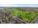 A birds eye view showcases a golf course with trees and homes surrounding it, next to a road at 1090 E 3Rd Ave, Denver, CO 80218