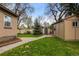 Spacious backyard featuring a lush lawn, mature trees, garden shed, and sidewalk connecting the home at 1090 E 3Rd Ave, Denver, CO 80218