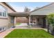 Backyard featuring covered patio, lush grass, and brick pathway at 1090 E 3Rd Ave, Denver, CO 80218