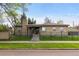 Charming brick home showcases a well-manicured lawn, secure fence, and classic architectural details at 1090 E 3Rd Ave, Denver, CO 80218