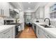 Stylish kitchen featuring gray cabinetry, stainless appliances, and view into dining area at 1090 E 3Rd Ave, Denver, CO 80218