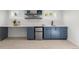 Basement wet bar with blue cabinets, white countertop, mini-fridge, sink, and open shelves provides convenience and style at 1090 E 3Rd Ave, Denver, CO 80218