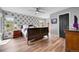 Spacious bedroom with hardwood floors, ceiling fan, wallpapered accent wall, and a large window at 14332 Craftsman Way, Broomfield, CO 80023