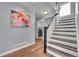 Hallway with stairs and view of laundry room; wood floors, painted walls, and colorful artwork at 14332 Craftsman Way, Broomfield, CO 80023