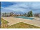 Community pool with lounge areas and stone buildings surrounded by mature trees, offering a relaxing atmosphere at 14332 Craftsman Way, Broomfield, CO 80023