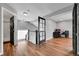 Bright upstairs hallway featuring hardwood floors, leading to an office and a bathroom with black framed door and white trim at 14332 Craftsman Way, Broomfield, CO 80023