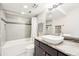 Modern bathroom featuring granite counters, stylish sink, and shower-over-tub with tiled walls at 2 Adams St # 705, Denver, CO 80206