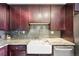 Close-up of the kitchen sink with stainless steel appliances, granite countertops, and gray backsplash at 2 Adams St # 705, Denver, CO 80206