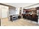 Open kitchen with a long breakfast bar island featuring chairs, light wood floors, and accent wood wall at 2 Adams St # 705, Denver, CO 80206