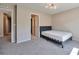 A well-lit bedroom featuring a modern bed frame, soft carpet, and a doorway to another room at 15818 E Otero Cir, Centennial, CO 80112