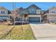 Beautiful two-story home featuring blue and gray siding, a covered porch, and a two-car garage at 15818 E Otero Cir, Centennial, CO 80112