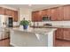 Kitchen island featuring granite countertops, dark cabinets and a stainless steel refrigerator at 15818 E Otero Cir, Centennial, CO 80112