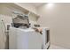 Laundry room with modern appliances, featuring a front-load washer and dryer with an open lid at 15818 E Otero Cir, Centennial, CO 80112