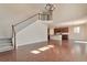 Spacious living room featuring hardwood floors, open staircase, and direct access to the kitchen at 15818 E Otero Cir, Centennial, CO 80112