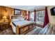 Bedroom features wood accent wall, rustic furniture, and balcony access with red curtains at 107 N Harris St # 111, Breckenridge, CO 80424