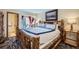 Tranquil bedroom featuring a rustic bed frame, balcony access, and soft lighting at 107 N Harris St # 111, Breckenridge, CO 80424