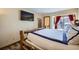 Comfortable bedroom with wood-frame bed, TV, and access to the balcony at 107 N Harris St # 111, Breckenridge, CO 80424