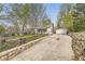 Long concrete driveway leading to a charming white house with a well-maintained front yard and chainlink fence at 5510 S Windermere St, Littleton, CO 80120