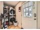 Compact laundry room with a washer, dryer, shelving, and an exterior door at 5510 S Windermere St, Littleton, CO 80120