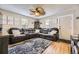 Living room featuring hardwood floors, a large leather sofa, decorative ceiling fan, and ample natural light at 5510 S Windermere St, Littleton, CO 80120