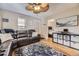 Inviting living room featuring hardwood floors, a ceiling fan, and comfortable dark brown leather sofa at 5510 S Windermere St, Littleton, CO 80120
