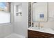 Bathroom with stylish wood vanity, modern fixtures, and tile-surround shower at 3942 Alcott St, Denver, CO 80211