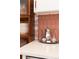 Elegant kitchen countertop with decorative backsplash, silver tea set, and wood cabinetry at 3942 Alcott St, Denver, CO 80211