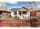 Charming home exterior with a well-maintained lawn, a cute fence, and solar panels on the roof at 3942 Alcott St, Denver, CO 80211