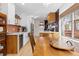 Sunlit kitchen with white cabinets, stainless steel appliances, and a large wooden dining table at 3942 Alcott St, Denver, CO 80211