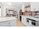 Open concept kitchen featuring white cabinets, modern appliances, and seamless flow to the living area at 3942 Alcott St, Denver, CO 80211