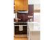 Modern kitchen featuring sleek black appliances, white countertop, and unique wood range hood and backsplash at 3942 Alcott St, Denver, CO 80211