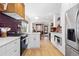 Bright kitchen features stainless steel appliances, white cabinetry, and an opening to the dining room at 3942 Alcott St, Denver, CO 80211