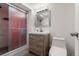 Bathroom featuring a vanity with drawers, a shower with glass doors and a white toilet at 6871 Locust St, Commerce City, CO 80022
