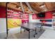Finished basement rec room with ping pong table, red accent wall, and fun decor at 7665 S Steele St, Centennial, CO 80122