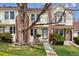 Charming townhome with manicured lawn, mature trees, and brick accents on the exterior at 7665 S Steele St, Centennial, CO 80122