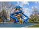 Community playground with a blue spiral slide, play structures and seating at 7665 S Steele St, Centennial, CO 80122