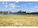 Outdoor community tennis court with chain-link fence, surrounded by green space at 7665 S Steele St, Centennial, CO 80122