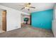 Finished basement with gray carpet, blue accent wall, ceiling fan, and access to other rooms at 12065 E Kentucky Ave, Aurora, CO 80012