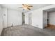 Finished basement with gray carpet, ceiling fan, white walls, and access to other rooms at 12065 E Kentucky Ave, Aurora, CO 80012