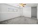 Finished basement with gray carpet, ceiling fan, white walls, and bright natural light from window with plantation shutters at 12065 E Kentucky Ave, Aurora, CO 80012