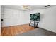 Finished basement with gray carpet, wood-look flooring, ceiling fan, white walls, and large flat-screen TV at 12065 E Kentucky Ave, Aurora, CO 80012