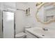 Bathroom with white vanity, decorative mirror and lighting, shower with glass doors and white toilet at 12065 E Kentucky Ave, Aurora, CO 80012