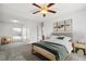 Well-lit bedroom featuring a bed, modern lighting, neutral walls and carpet, and natural light from the window at 12065 E Kentucky Ave, Aurora, CO 80012