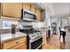 Cozy kitchen featuring stainless steel appliances, wood cabinets, light countertops, and view to breakfast nook at 12420 E Iliff Pl, Aurora, CO 80014